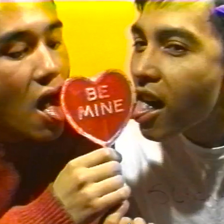 two men share cheesy expressions about a valentine's day candy heart 